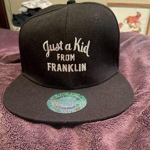 A black hat that says just a kid from Franklin
